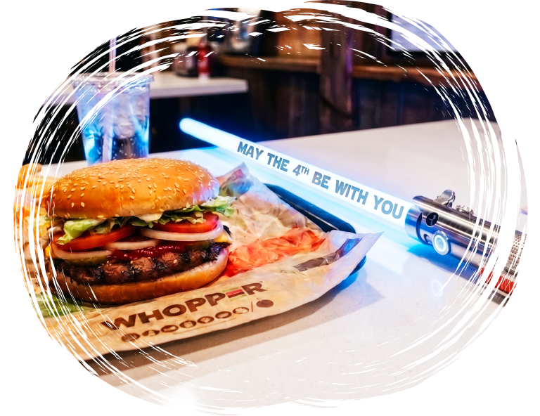 Burger meal with themed lightsaber prop displaying May the 4th message on table
