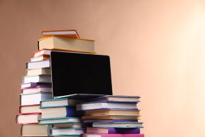 Laptop sitting upon a stack of books